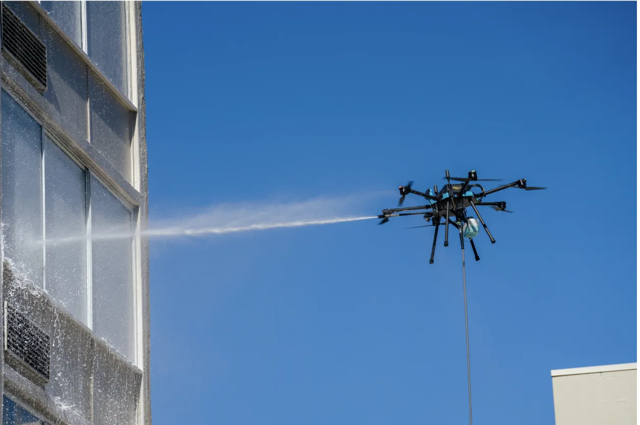 Drone Exterior Cleaning — 14-Story Office Building Facade Wash Cleaning drone washing the facade of a 14-story office building